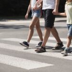 Father holding hands with his kids while on pedestrian crossing