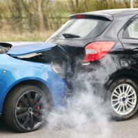 Two Damaged Cars Involved In Road Traffic Accident Showing Smoke